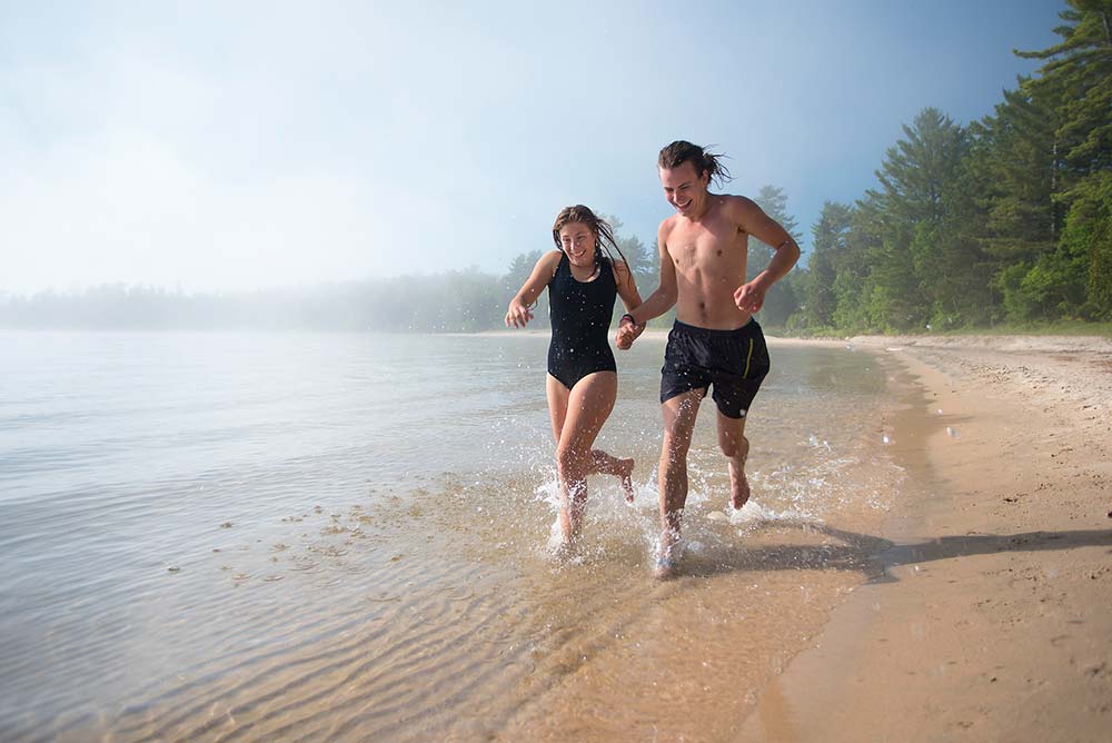 couple running into the water on a beach