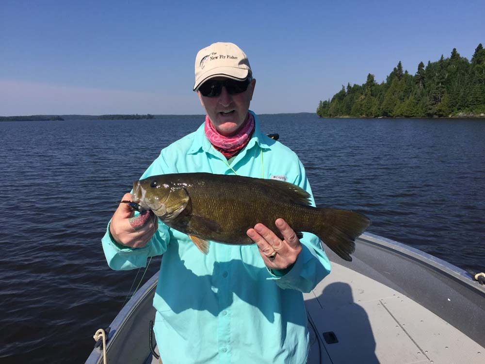 fly angler holding ontario smallmouth bass